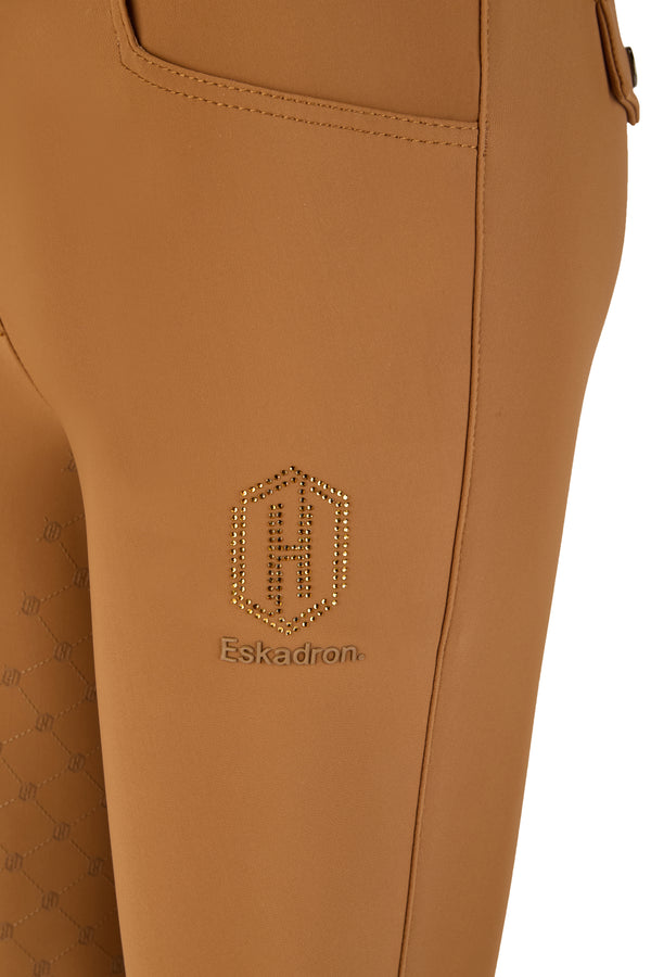 "Plan rapproché d'un pantalon d'équitation marron de la marque Eskadron, avec un logo doré formant un "H" en strass sur le côté."