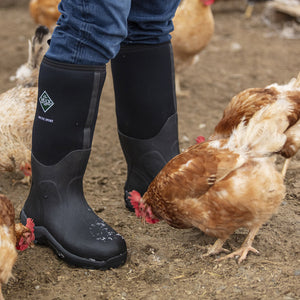 Bottes Muck Boot Arctic Sport High portées au poulailler, au milieu des poules