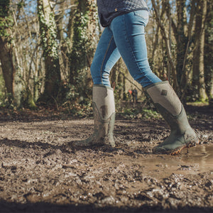 Bottes Muck Boot Arctic Sport II Tall vertes portees dans un chemin boueux