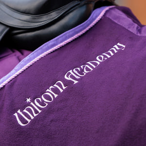 Lettrage Unicorn Academy brode sur la couverture sechante violette