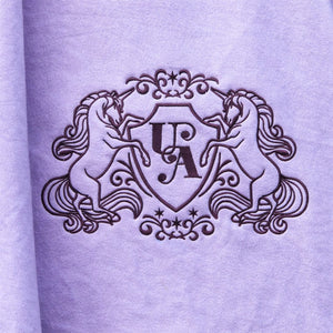 Blason Unicorn Academy brode sur la couverture sechante lilas