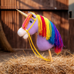 Cheval baton Unicorn Academy Wildstar pose sur une botte de paille