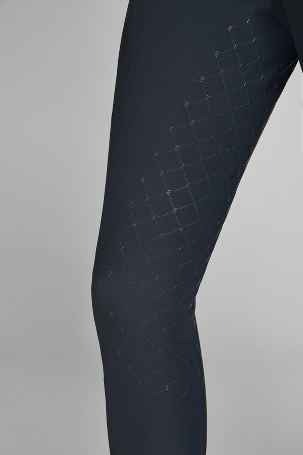 Pantalon noir ajusté avec motif hexagonal ton sur ton texturé sur la jambe, pris en vue rapprochée.