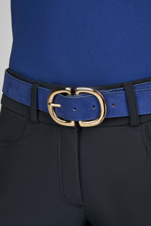 Gros plan sur une ceinture en daim bleu avec une boucle dorée, portée sur un pantalon noir. Le haut visible est bleu et ajusté.