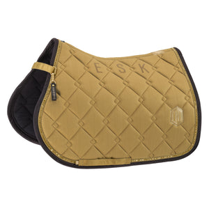 L'image représente une selle d'équitation de couleur moutarde. Voici une description détaillée : 1. **Couleur et Design** : - La selle est principalement de couleur moutarde, avec un motif matelassé en losanges qui lui donne un aspect élégant et sophistiqué. - Le bord de la selle est orné d'une fine ligne dorée, ajoutant une touche de luxe. 2. **Détails et Ornements** : - Sur le côté droit de la selle, il y a un emblème en forme de "H" doré, probablement le logo de la marque. -...