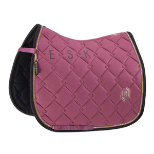 L'image montre une selle d'équitation, plus précisément une selle de type tapis de selle, qui est conçue pour être placée sous la selle afin d'offrir confort et protection à la fois au cheval et au cavalier. Voici une description détaillée de l'objet : - **Matériau et Design** : La selle est fabriquée dans un matériau qui semble être du tissu matelassé, offrant une apparence lisse et uniforme. Le design présente un motif en losanges formé par des coutures diagonales croisées, créant un effet...