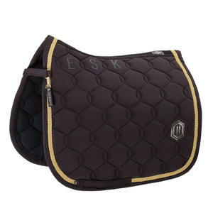 L'image présente une selle d'équitation de couleur marron foncé, richement ornée et conçue avec soin. La selle est principalement en cuir ou en matériau synthétique de haute qualité et est dotée d'un motif de quilting en losanges élégant qui lui donne une apparence sophistiquée et texturée. Les bords de la selle sont agrémentés d'une fine bordure dorée, ajoutant une touche de luxe et d'élégance. Sur le côté supérieur gauche de la selle, on peut voir trois lettres brodées en gris : "E", "S"...