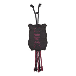 L'image présente un jouet pour chien en forme d'animal, plus précisément ce qui semble être un ours ou un animal similaire. Le jouet est principalement noir et est orné du mot "ESKADRON" en lettres roses verticales sur son corps. Le jouet est conçu avec des éléments interactifs pour divertir un chien. Il a deux "bras" en forme de corde noire, chacun terminé par un nœud, situés au sommet de la tête. À l'extrémité inférieure, il y a trois "pattes" ou " appendices" en corde, chacune formée de...