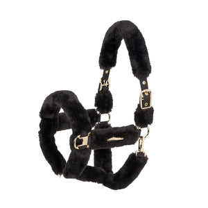 L'image présente un licol de cheval noir luxueux et élégant, conçu avec une attention particulière aux détails. Le licol est principalement noir et est doté de plusieurs éléments distinctifs. 1. **Matériau et Texture** : - La partie extérieure du licol est recouverte d'un matériau doux et pelucheux, probablement de la fausse fourrure, ce qui donne une apparence luxueuse et confortable. - La partie intérieure semble être en cuir ou en matériau synthétique robuste, offrant une durabilité...