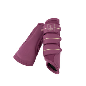 L'image montre une paire de protège-boulets, des accessoires équestres utilisés pour protéger les jambes des chevaux. Ces protège-boulets sont de couleur bordeaux avec des accents beiges. Voici une description détaillée : 1. **Matériau et Couleur** : Les protège-boulets sont fabriqués dans un matériau qui semble être un mélange de cuir synthétique et de tissu perforé pour la ventilation. La couleur principale est un bordeaux profond, et il y a des bandes beiges verticales qui servent de...