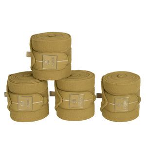 L'image présente un ensemble de quatre bandages pour chevaux, disposés en une pyramide soigneuse. Chaque bandage est cylindrique et de couleur beige clair, donnant une apparence homogène et élégante. Les bandages sont maintenus ensemble par des sangles de même couleur, chacune ornée d'un logo distinct. Le logo comprend un hexagone avec un motif en relief, encadré par un rectangle doré. Le logo semble être celui de la marque "Eskadron", reconnue pour ses accessoires équestres de haute qualité....
