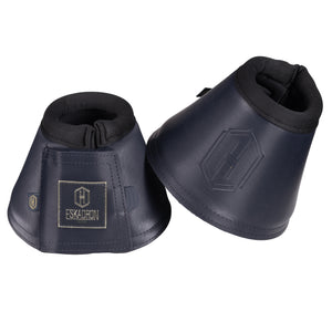 L'image montre une paire de protège-boulets pour chevaux de la marque Eskadron. Les protège-boulets sont conçus pour protéger les boulets (la partie inférieure des membres) du cheval contre les blessures et les irritations. Voici une description détaillée : 1. **Matériau et Couleur** : Les protège-boulets sont fabriqués dans un matériau synthétique, probablement du cuir synthétique ou du néoprène, qui offre une bonne résistance et flexibilité. Ils sont de couleur bleu foncé avec des nuances...