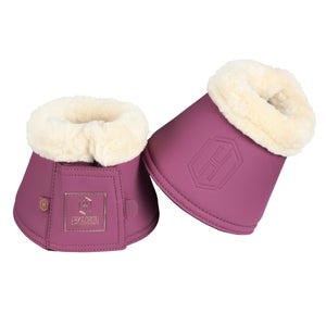 L'image montre deux protège-boulets pour chevaux, disposés côte à côte. Les protège-boulets sont de couleur rose foncé avec une bordure en fourrure blanche en haut. Chaque protège-boulet possède une fermeture velcro sur le côté, permettant un ajustement facile et sécurisé. Sur le côté de chaque protège-boulet, il y a un emblème brodé en doré avec une forme géométrique et le texte "ESKADRON" en dessous. Cet emblème est élégant et ajoute une touche de sophistication à l'article. La présence...