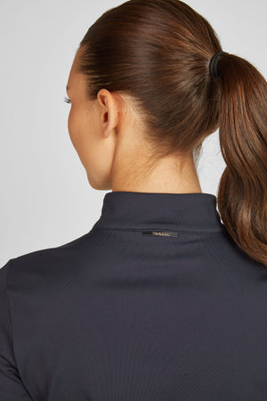 L'image montre l'arrière-plan d'une femme avec une vue en gros plan de son cou et de ses cheveux. La femme a les cheveux bruns attachés en queue de cheval haute et serrée, maintenue par un élastique noir. Sa chevelure est soigneusement tirée en arrière, sans mèches dépassant, ce qui donne un aspect soigné et ordonné. Elle porte un vêtement à col montant de couleur sombre, probablement noir ou gris foncé, avec une texture légèrement texturée. Le col du vêtement est haut et ajusté, couvrant la...