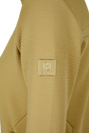 L'image montre un vêtement de couleur beige clair avec un motif tricoté en relief. Le tissu semble être en maille, offrant une texture texturée et douce. Sur le côté gauche du vêtement (visible sur l'image), il y a un badge rectangulaire doré. Ce badge est bordé d'une fine ligne dorée et contient une série de lignes verticales au centre, ainsi que le mot "Fskathon" écrit en dessous. Le badge est solidement cousu sur le tissu, ajoutant une touche élégante et distinctive à la pièce. L'aspect...