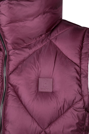 L'image montre l'intérieur d'une veste ou d'un gilet matelassé de couleur bordeaux. La doublure est composée d'un tissu fin et léger, probablement synthétique, avec des coutures bien définies formant des losanges. Les coutures sont précises et régulières, assurant une répartition uniforme de la ouate. On peut voir une fermeture éclair sur le côté gauche de l'image, suggérant que la veste se ferme par l'avant. La fermeture éclair semble de bonne qualité, avec des dents bien alignées et un...